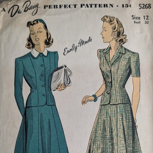 Może przedstawiać: Wzorzec szycia vintage do dwuczęściowej sukienki, rozmiar 12, biust 76 cm. Wzorzec nazywa się "Perfect Pattern" i pochodzi od Du Barry Patterns Ltd. Wzorzec jest przeznaczony do sukienki z dopasowanym gorsetem i pełną spódnicą. Wzorzec jest zilustrowany dwiema kobietami noszącymi sukienkę, jedna w jednolitym kolorze zielonym, a druga w kratę.