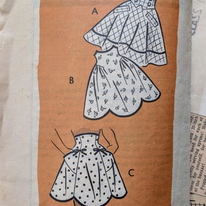 Könnte beinhalten: Vintage-Schnittmuster für drei verschiedene Schürzenmodelle. Das Muster ist auf braunem Papier mit Schwarzweißillustrationen gedruckt. Die Musternummer ist 4859 und die Größe ist Mittel.