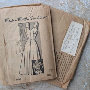 Puede incluir: Patrón de costura vintage de Marian Martin Sew-Chart. El patrón presenta un diseño de vestido con corpiño ajustado y falda acampanada. Talla 12. El sobre es de color beige con ilustraciones y texto en negro.