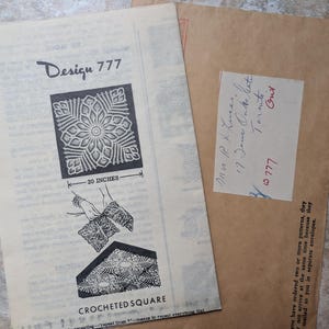 May include: A vintage paper pattern for a crocheted square titled Design 777, featuring a black and white illustration of a floral motif and a 20 inches measurement label. It is accompanied by a brown mailing envelope with a handwritten address label.