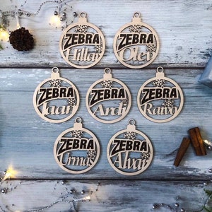 May include: Seven wooden ornaments with the word "ZEBRA" and a different name on each ornament. The names are "Hillar", "Olev", "Ivaar", "Ardi", "Raivo", "Urnas", and "Alvar".