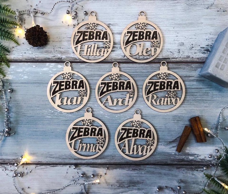 May include: Seven wooden ornaments with the word "ZEBRA" and a different name on each ornament. The names are "Hillar", "Olev", "Ivaar", "Ardi", "Raivo", "Urnas", and "Alvar".