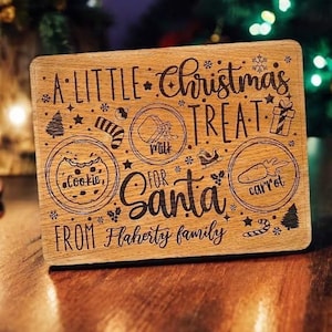 May include: A wooden sign with the text "A Little Christmas Treat for Santa from Flaherty family" with illustrations of a cookie, milk, and a carrot.