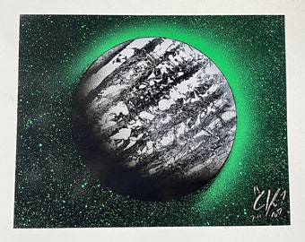 Black and white planet with green stars and shine