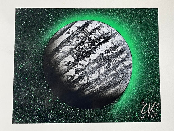 Planets painted with shining watercolor paints on black watercolor