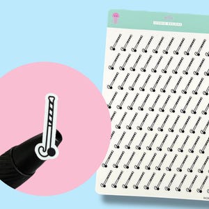 May include: Sheet of stickers featuring a repeating pattern of black and white hockey sticks. A single sticker is shown up close, held against a pink background. The sticker sheet has a light green header with the text "jelly STUDIO DESIGNS".