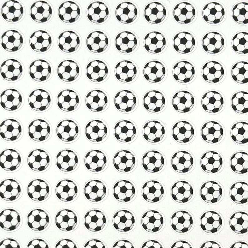May include: A grid of small, circular stickers featuring black and white soccer balls. The soccer balls have a classic pentagon and hexagon pattern. The stickers are arranged in neat rows and columns on a white background.