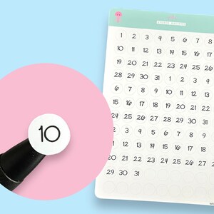 May include: A sheet of white circle stickers with black numbers 1 through 31. The stickers are arranged in a grid pattern. A single sticker with the number 10 is highlighted.