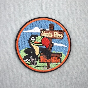 Peut inclure: Écusson brodé circulaire avec un toucan et une enseigne indiquant "Costa Rica" et "Punta Vile". Le patch a un fond de ciel bleu et une bordure orange. Un souvenir de voyage coloré.