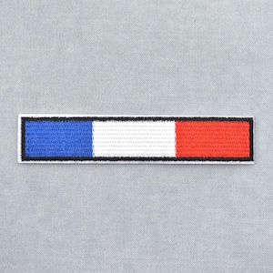 Peut inclure: Écusson brodé rectangulaire avec des rayures bleues, blanches et rouges, bordées de noir. Ce patch est destiné à être appliqué sur des vêtements ou des accessoires, et le code couleur rappelle un drapeau national.