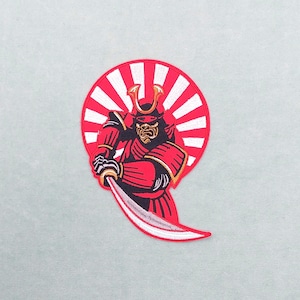 May include: Embroidered patch depicting a red samurai warrior with a katana, set against a red and white sunburst. The samurai has gold detailing on the helmet and armour. This patch is designed for application on clothing or accessories.