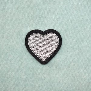 Embroidered silver heart patch with black border, iron-on, to customize clothing and accessories