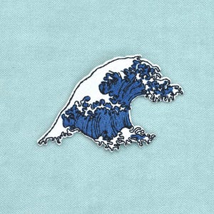 Pode incluir: Um emblema bordado com um design estilizado de uma onda oceânica. A onda é representada em tons de fio azul-escuro e branco, capturando o movimento da crista da água com detalhes de costura intrincados sobre um fundo de tecido azul-claro.