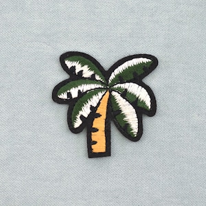 May include: Embroidered palm tree patch with a black border. The palm fronds are green and white, and the trunk is yellow. The patch is on a light blue fabric background.