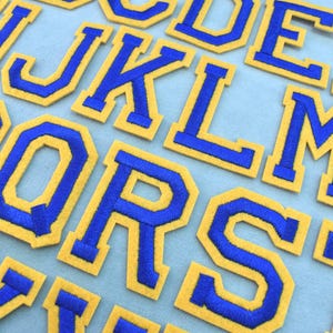 Parches termoadhesivos con letras del alfabeto bordadas en azul y amarillo, insignias estilo universitario, personalizables.