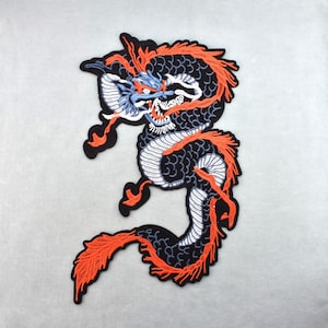 Pode incluir: Patch de dragão bordado em preto, laranja, branco e azul. O design do dragão apresenta detalhes intrincados, incluindo escamas e detalhes laranja fluindo. O patch é provavelmente para roupas ou acessórios.