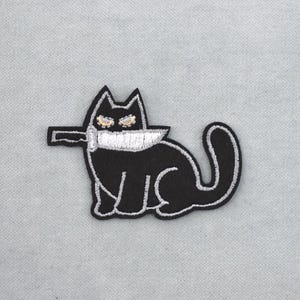 Broderad svart tygmärke med den skyldiga katten, strykbar broderad tygmärke