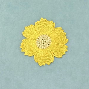 Peut inclure: Un écusson brodé en forme de fleur jaune avec huit pétales distincts aux bords dentelés et un centre texturé de couleur crème clair. La broderie utilise un travail de fil dense et rayonnant pour créer un motif floral détaillé sur un tissu.