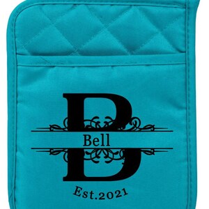 May include: Teal quilted oven mitt with a black letter "B" and the text "Bell Est. 2021" in a decorative font.