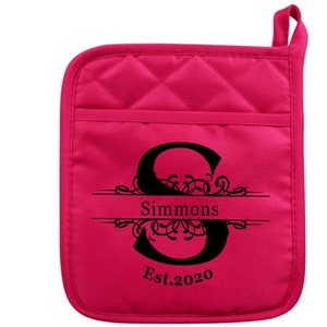 May include: Hot pink quilted oven mitt with a black monogrammed initial "S" with the name "Simmons" and the text "Est. 2020" in a decorative font.