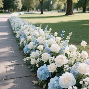 Könnte beinhalten: Ein Weg, gesäumt von einem Blumengesteck aus weißen Rosen, blauen Hortensien und zarten blauen Wildblumen. Die Blumen sind in einer durchgehenden Linie entlang eines Steinwegs angeordnet.
