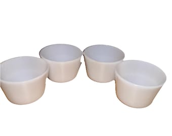 May include: Set of four white milk glass custard cups. The cups are round with a slightly flared rim.