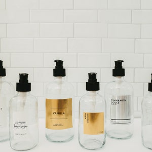 Puede incluir: Seis botellas de vidrio transparente con tapas de bomba negras y etiquetas. Las etiquetas tienen letras doradas y enumeran diferentes aromas: Coco, Canela Az&uacute;car Moreno, Vainilla, Chocolate Blanco, Canela Dolce y Jarabe Simple.