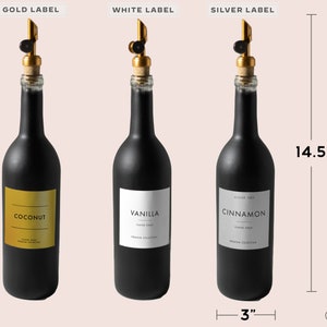K&ouml;nnte beinhalten: Drei schwarze Glasflaschen mit goldenen, wei&szlig;en und silbernen Etiketten. Die Flaschen sind 36,8 cm hoch und 7,6 cm breit. Die Etiketten zeigen "Coconut", "Vanilla" und "Cinnamon".