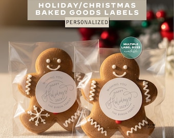 May include: Two gingerbread man cookies in clear packaging, each with a white circular label that reads "Wishing You Happy Holidays 2029 The Byron Family." The image also includes text that says "Holiday/Christmas Baked Goods Labels Personalized."