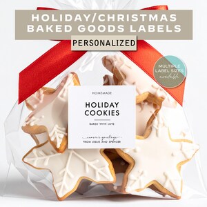 May include: A clear cellophane bag tied with a red ribbon, filled with star-shaped cookies. The cookies are decorated with white icing and a snowflake design. The label reads "HOLIDAY COOKIES" and "PERSONALIZED".
