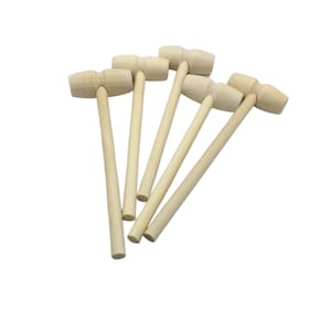 May include: A collection of six small, light-colored wooden mallets. Each mallet has a rounded head and a long, cylindrical handle. The mallets are arranged in a fan-like pattern against a white background.