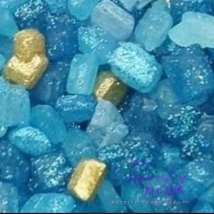 Puede incluir: Primer plano de una mezcla de chispas comestibles azules y doradas. Las chispas azules tienen una apariencia cristalina, mientras que las chispas doradas tienen forma de cubo. La imagen también incluye el texto "Tiffany Blends" y "Mattise Sweet Treats".