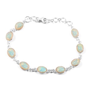 May include: A silver chain bracelet with oval-shaped white opal gemstones. The bracelet has a lobster claw clasp.