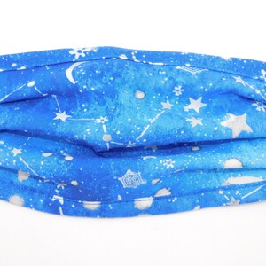 Op de afbeelding: Een blauw mondkapje met een wit sterrenbeeldpatroon. Het masker heeft een geplooid ontwerp en is gemaakt van stof.