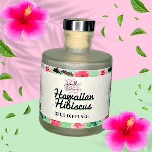 May include: A clear glass bottle with a silver lid and a white label. The label says "Rosellla's Radiance Hawaiian Hibiscus Reed Diffuser". The bottle is surrounded by pink hibiscus flowers and green leaves.