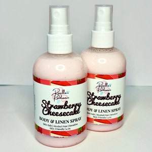 Puede incluir: Dos botellas rosas de spray para el cuerpo y la ropa de fresa y cheesecake. Las botellas est&aacute;n etiquetadas "Borella's Radiance Strawberry Cheesecake Body & Linen Spray" y presentan un dise&ntilde;o de fresa y cheesecake. Cada botella contiene 118 ml.
