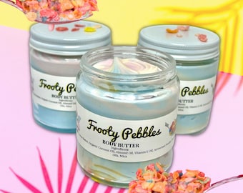 May include: Three glass jars of body butter with a blue and white swirl design. The jars are labelled "Frooty Pebbles Body Butter" and "Pebbles Butter". The jars are sitting on a pink and yellow background with a spoon full of colourful cereal.