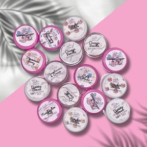 Puede incluir: Surtido de pequeños recipientes rosas y blancos con etiquetas para diferentes mantecas corporales y exfoliantes de azúcar. Las etiquetas presentan diferentes diseños y textos, incluyendo "Brown Sugar & Fig", "Strawberry Cream", "Banana Bread", "Pumpkin Waffle" y "Orange Vanilla".