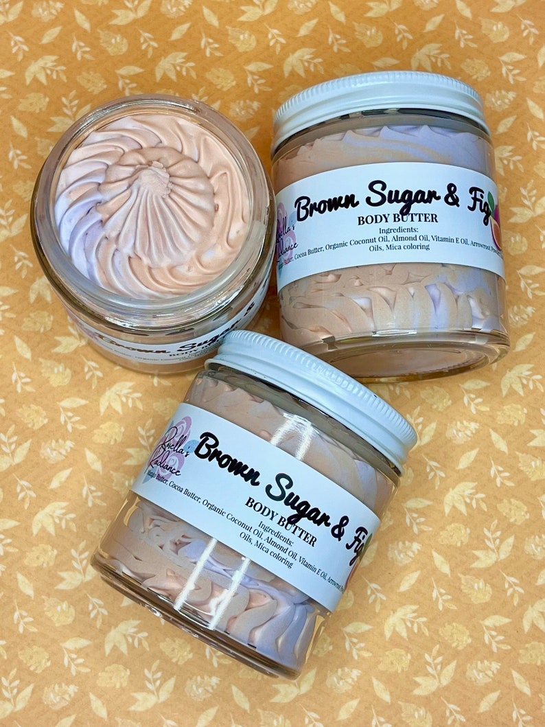 Puede incluir: Dos tarros de vidrio de manteca corporal con tapas blancas. Los tarros est&aacute;n llenos de un remolino de manteca corporal marr&oacute;n claro y morado. Las etiquetas en los tarros dicen "Brown Sugar & Fig" y enumeran los ingredientes: manteca de cacao, aceite de coco org&aacute;nico, aceite de almendras, aceite de vitamina E y colorante mica.
