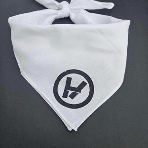 Könnte beinhalten: Weißes Bandana mit einem schwarzen Kreis und den Buchstaben "V" und "X" darin.