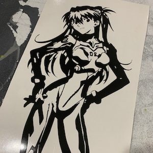 May include: Black and white silhouette of an anime character with long hair and a ponytail. The character is wearing a jumpsuit with the number "02" on the chest.