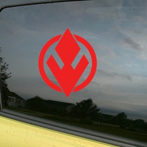 May include: A red and white symbol with a diamond shape in the centre, surrounded by a circle. The symbol is on a black background.