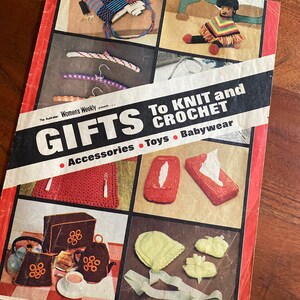 May include: A vintage magazine cover titled "Gifts to Knit and Crochet" featuring a variety of crocheted items, including a poncho, a tissue box cover, a teapot cosy, and baby booties. The magazine is published by The Australian Women's Weekly.