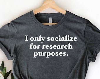 May include: A dark heather grey t-shirt with the text "I only socialize for research purposes." printed in white.