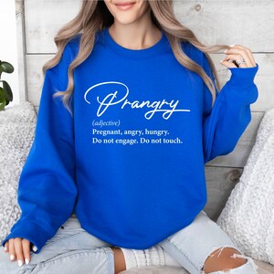 May include: A royal blue sweatshirt with white text that reads "Prangry (adjective) Pregnant, angry, hungry. Do not engage. Do not touch."