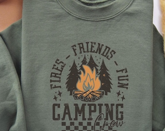 Könnte beinhalten: Grünes Sweatshirt mit einem Grafikdesign eines Lagerfeuers mit dem Text "Fires - Friends - Fun" und "Camping Crew" im Vintage-Stil.