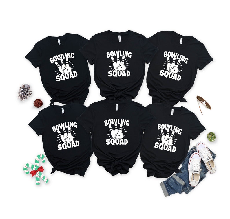 May include: Six black t-shirts with white text that reads "Bowling Squad" and a graphic of a bowling ball and pins.