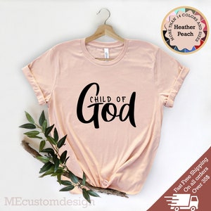 May include: A peach coloured t-shirt with the text "CHILD OF God" in black lettering.