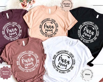 May include: Five t-shirts in different colors with the text "Warm - Compassionate - Caring - Loving - Dedicated - Fun - Reliable - Loyal - Kind" surrounding a circle with the text "Para Squad" inside. The t-shirts are available in Heather Mauve, Heather Peach, White, and Black.
