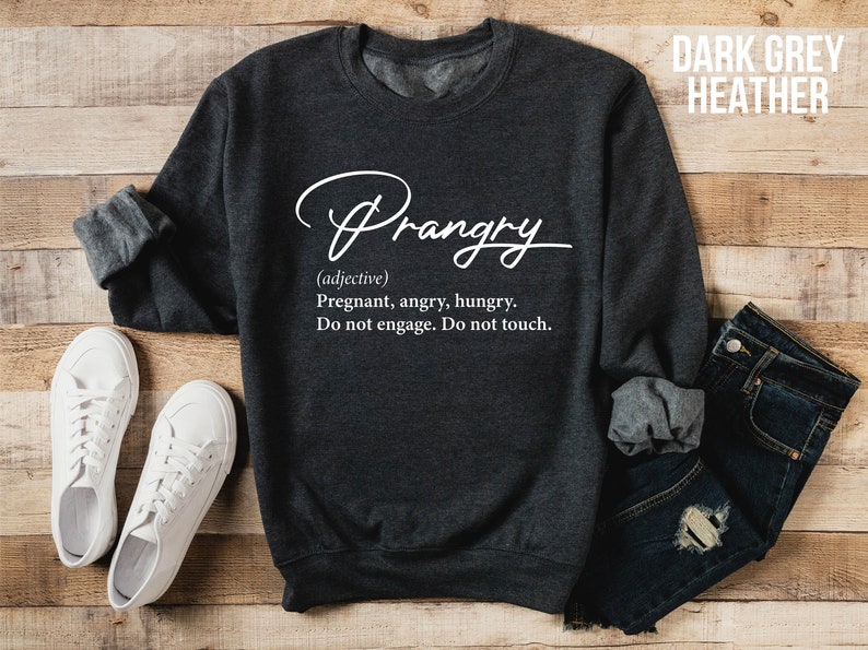 May include: Dark grey heather sweatshirt with the word "Prangry" written in white cursive. The text below defines "Prangry" as an adjective meaning "Pregnant, angry, hungry. Do not engage. Do not touch."